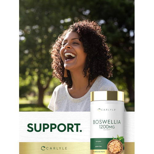 View 6 A smiling Black woman laughs outdoors next to a Carlyle Boswellia bottle.
