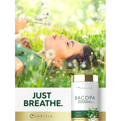 View 6 A young woman lies in the grass holding dandelions next to a Bacopa supplement bottle.