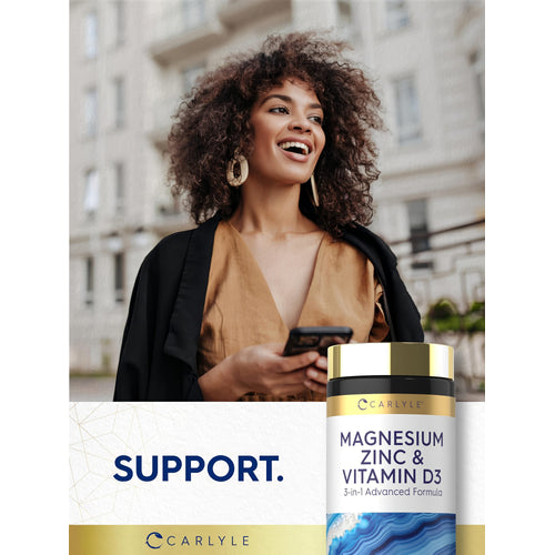 View 6 Young woman smiling and looking away while holding a smartphone, next to a Carlyle Magnesium Zinc & Vitamin D3 bottle.