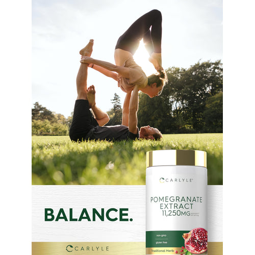 View 6 Two adults practicing acroyoga in a park with a bottle of Carlyle Pomegranate Extract nearby.