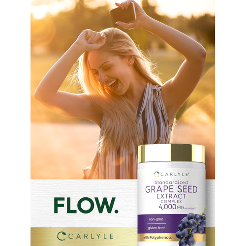 View 6 Laughing young woman outdoors holding a phone and a bottle of Carlyle Grape Seed Extract Complex.