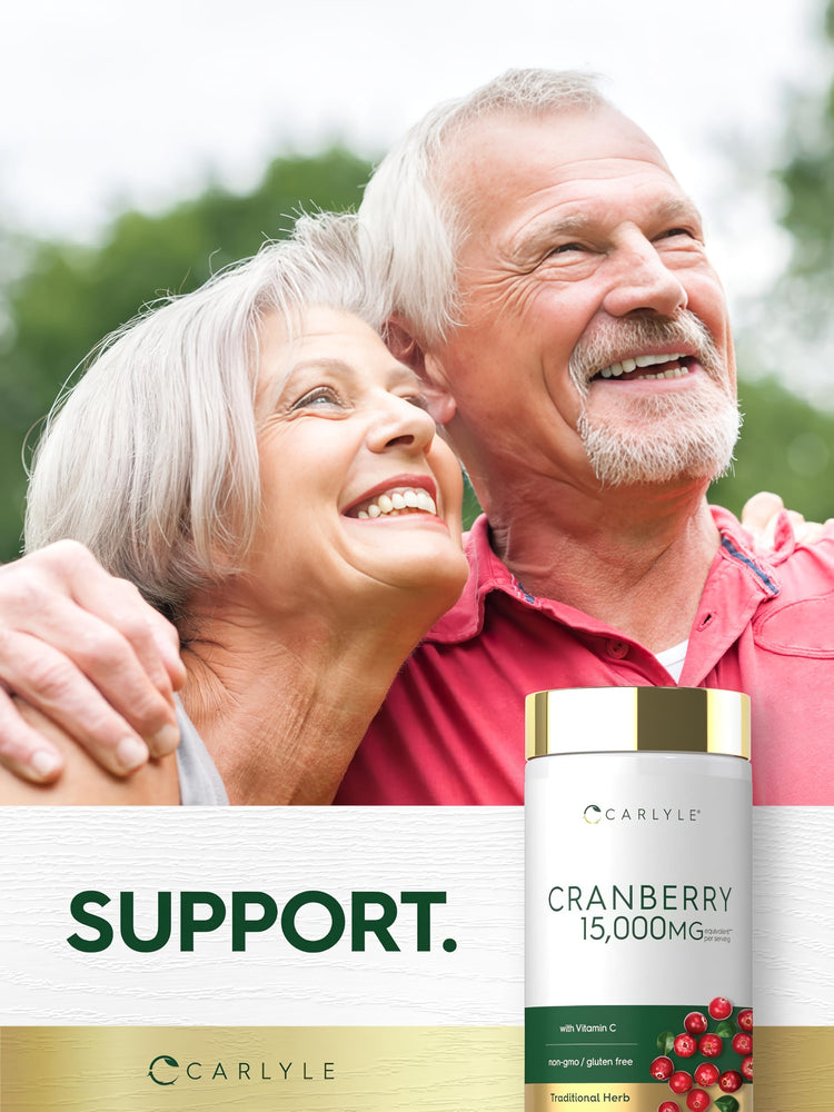 Elderly couple smiling and embracing outdoors with a Carlyle Cranberry supplement bottle nearby.