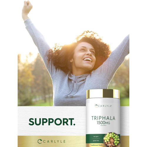 View 5 A young adult woman smiles with arms raised outdoors, next to a Carlyle Triphala bottle.