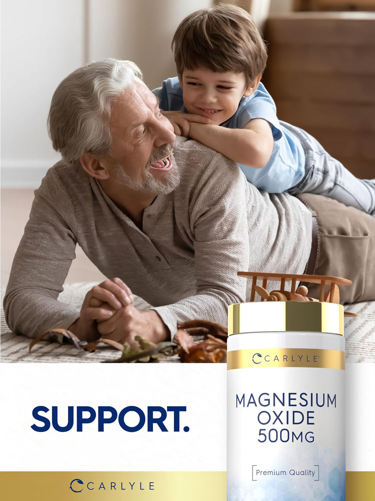 Older man and young boy laughing and playing on the floor with a Carlyle Magnesium Oxide 500 mg bottle nearby.