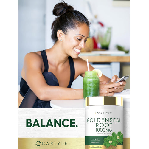 View 6 A young woman smiles at her phone beside a green smoothie and a bottle of Carlyle Goldenseal Root.