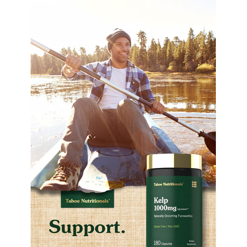 View 6 Adult man smiling while kayaking on a lake with a Tahoe Nutritionals Kelp 1000mg bottle nearby.