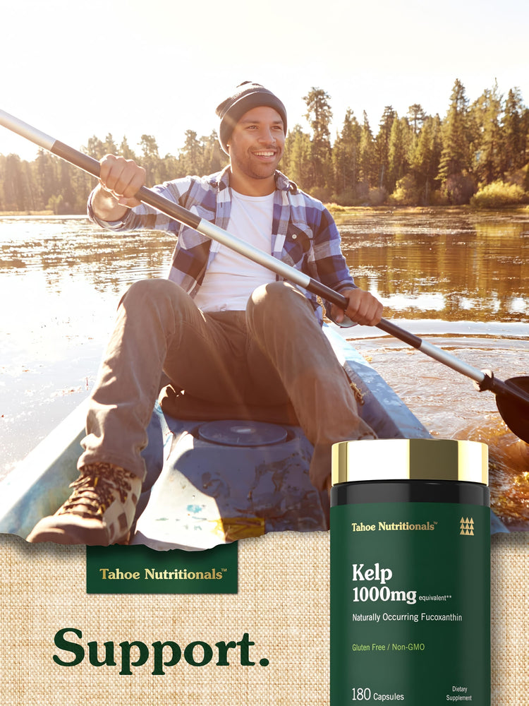 Adult man smiling while kayaking on a lake with a Tahoe Nutritionals Kelp 1000mg bottle nearby.