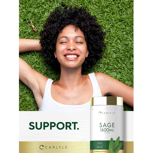 View 6 Young woman smiling, lying on grass with hands behind head, next to a Carlyle Sage bottle.
