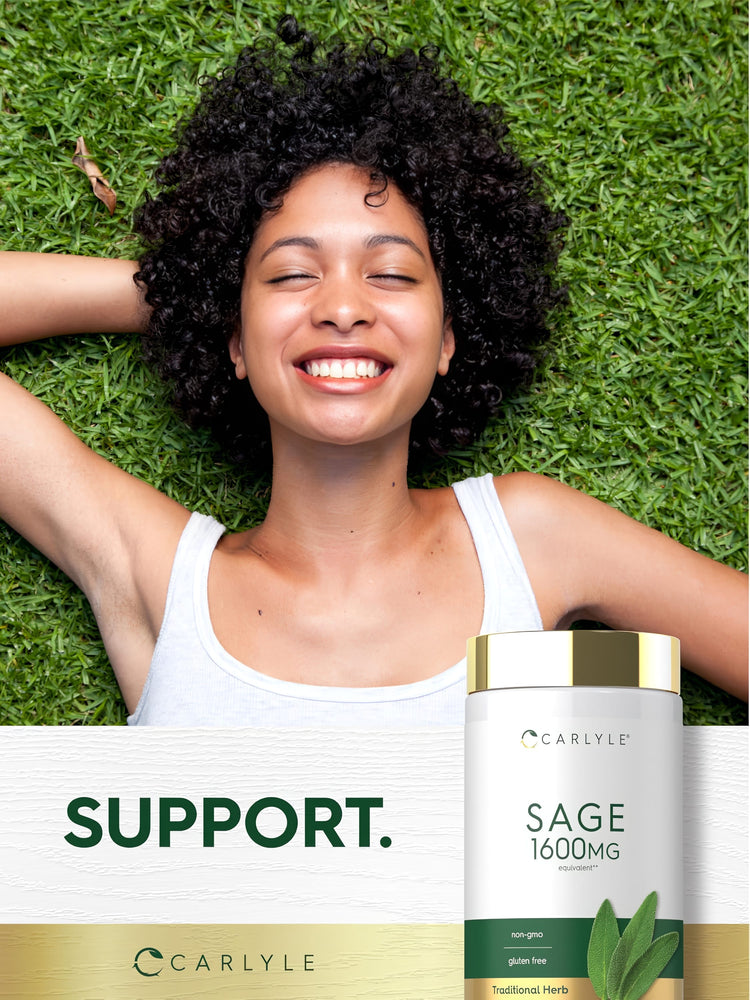 Young woman smiling, lying on grass with hands behind head, next to a Carlyle Sage bottle.