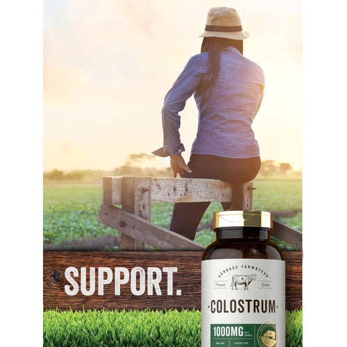 View 6 An adult woman sits on a wooden fence in a field, with the text 'SUPPORT' and a bottle of Herbage Farmstead Colostrum.