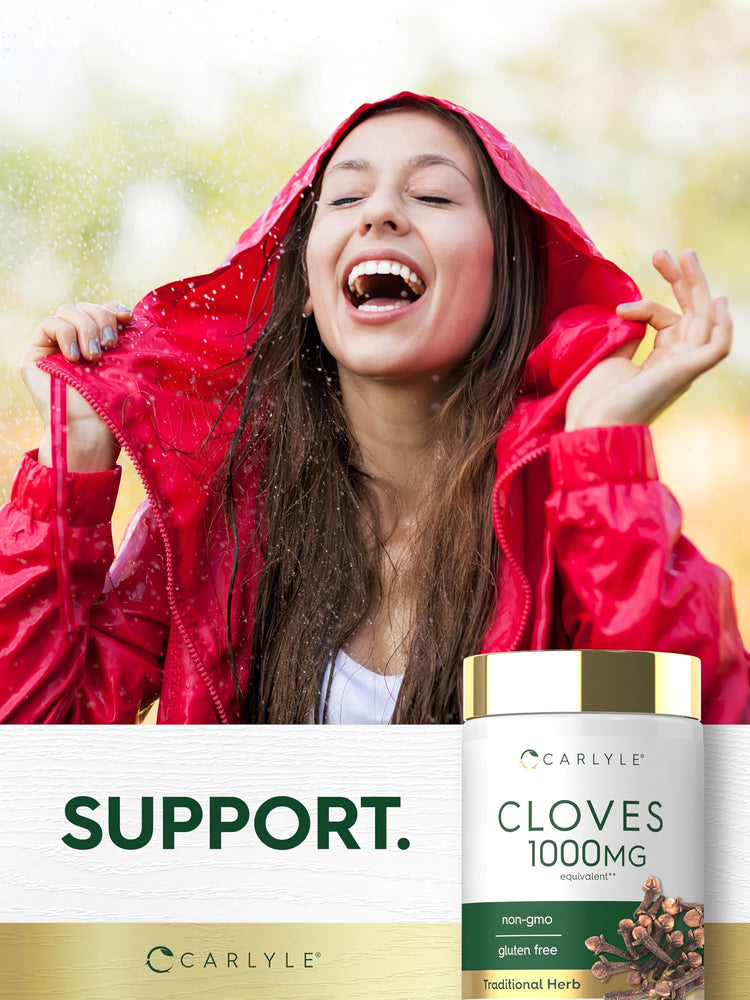 Young woman smiling in a red raincoat during rain, holding a Cloves 1000mg supplement bottle.