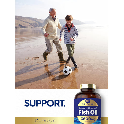 View 7 An older man and young boy play soccer on a beach, featuring a bottle of Carlyle Fish Oil nearby.