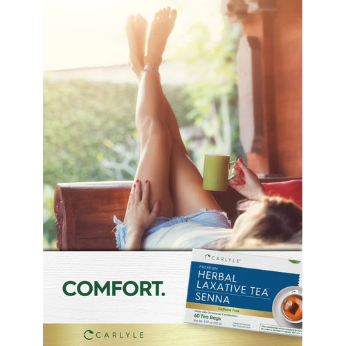 View 12 Lifestyle image of woman relaxing with her feet up while holding a mug, Carlyle Herbal Laxative Tea Senna box nearby, and graphic stating COMFORT.