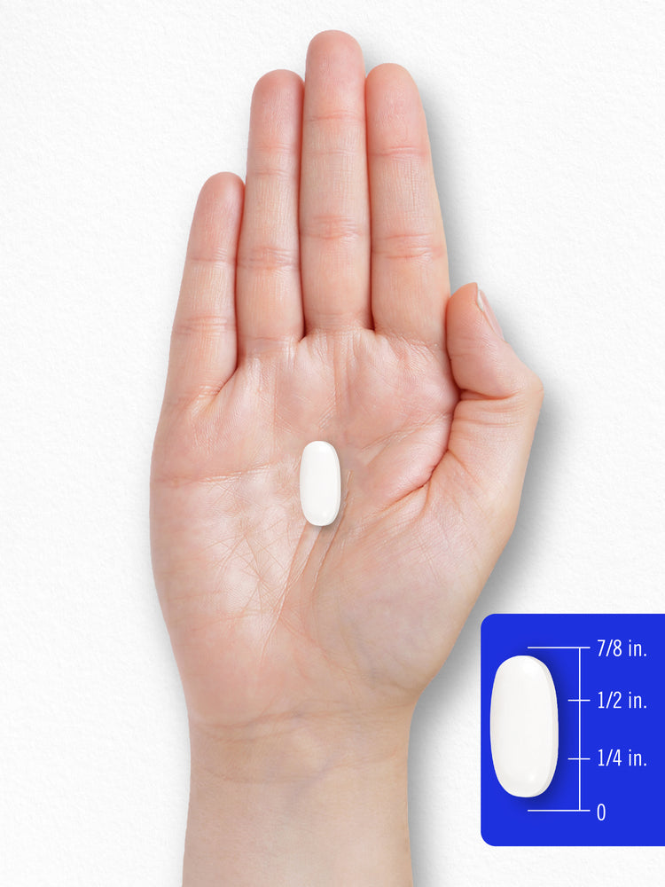 A white oval pill is shown on a hand next to a scale, measuring its length as seven-eighths of an inch.