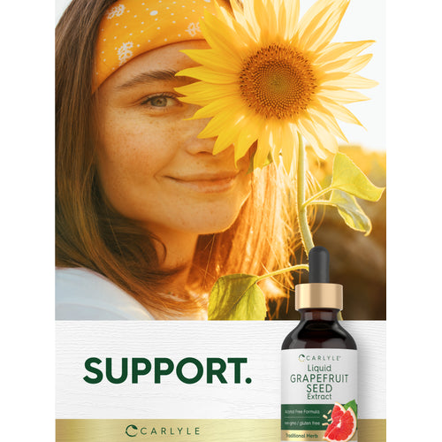 View 9 Lifestyle image of woman holding a sunflower with Liquid Grapefruit Seed Extract bottle nearby and graphic stating SUPPORT.