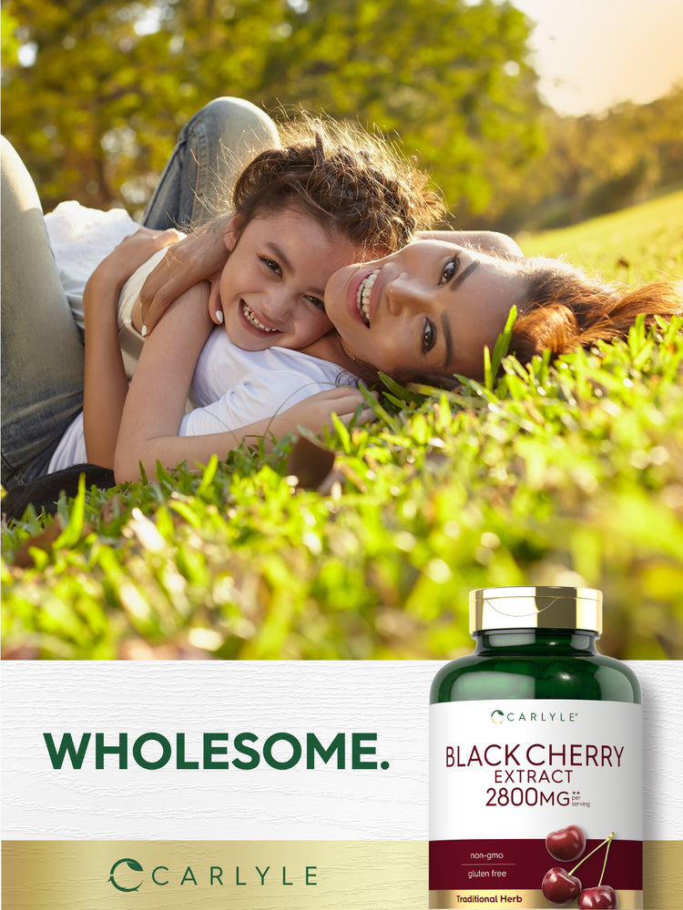Lifestyle image of an adult and child lying together on grass with Carlyle Black Cherry Extract 2800 mg bottle and graphic stating WHOLESOME.