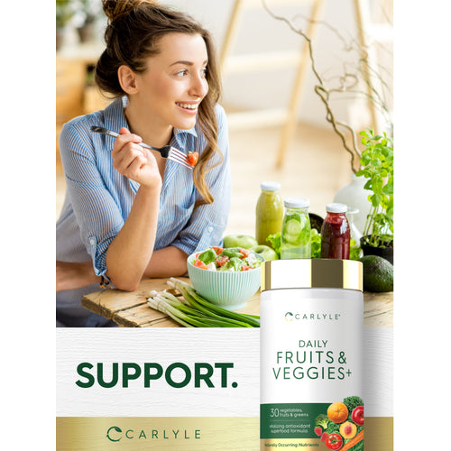 View 6 A woman enjoys a salad at a wooden table with healthy foods, next to a Daily Fruit & Veggies bottle.
