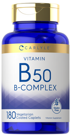 Carlyle B-50 Vitamin B-Complex bottle containing 180 vegetarian coated caplets, displayed on a hand scale for bulk measure.