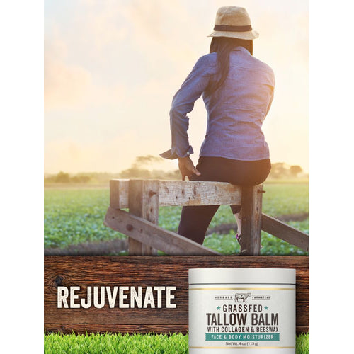 View 6 An adult woman sits on a wooden fence gazing at a field, holding a jar of Tallow with Collagen Balm.