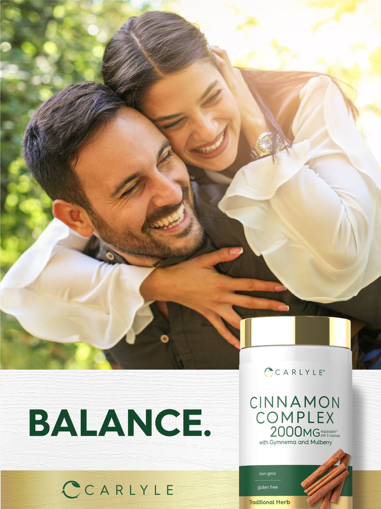 A joyful couple embraces and laughs, holding a Carlyle Cinnamon Complex bottle.