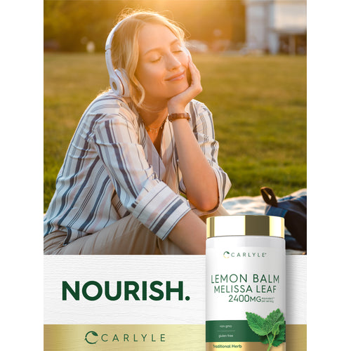 View 6 Young woman relaxing outside, listening to music with headphones, next to a Carlyle Lemon Balm Melissa Leaf bottle.