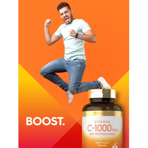 View 7 A young man jumps excitedly with fists clenched next to a Carlyle Vitamin C-1000mg with Bioflavonoids bottle.